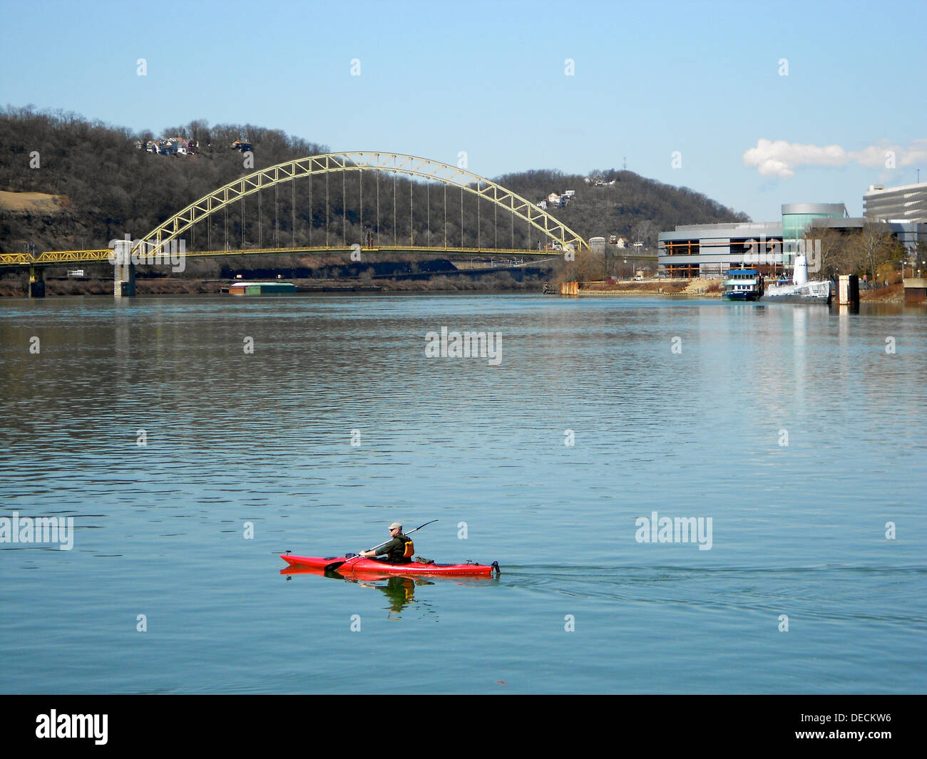 Un canoista pedala lungo il fiume Allegheny a Pittsburgh, vicino alla confluenza con il fiume Monongahela a The Forks of the Ohio, un punto di riferimento storico. Il primo ponte sul fiume Ohio è visibile sullo sfondo. Foto Stock