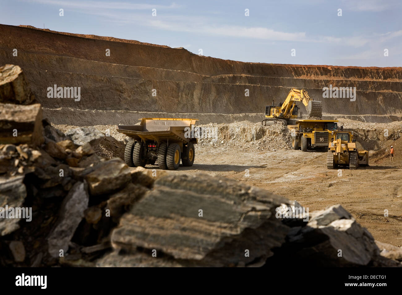 Miniera d'oro il funzionamento in apertura della superficie in ghisa pit con escavatore e raggio di lavoro carrelli, Mauritania, Africa nordoccidentale Foto Stock