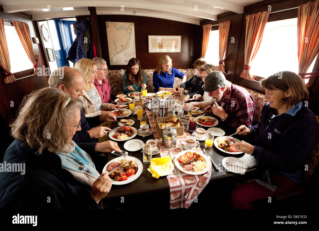 Un gruppo di persone di mangiare la prima colazione su una barca, la signora Firenze crociera, Orford, Suffolk REGNO UNITO Foto Stock