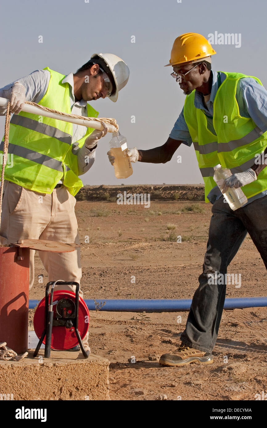 Prendendo campioni di acqua dal foro di trivellazione, per testare la qualità su oro industriale complesso minerario, Mauritania, Africa nordoccidentale Foto Stock