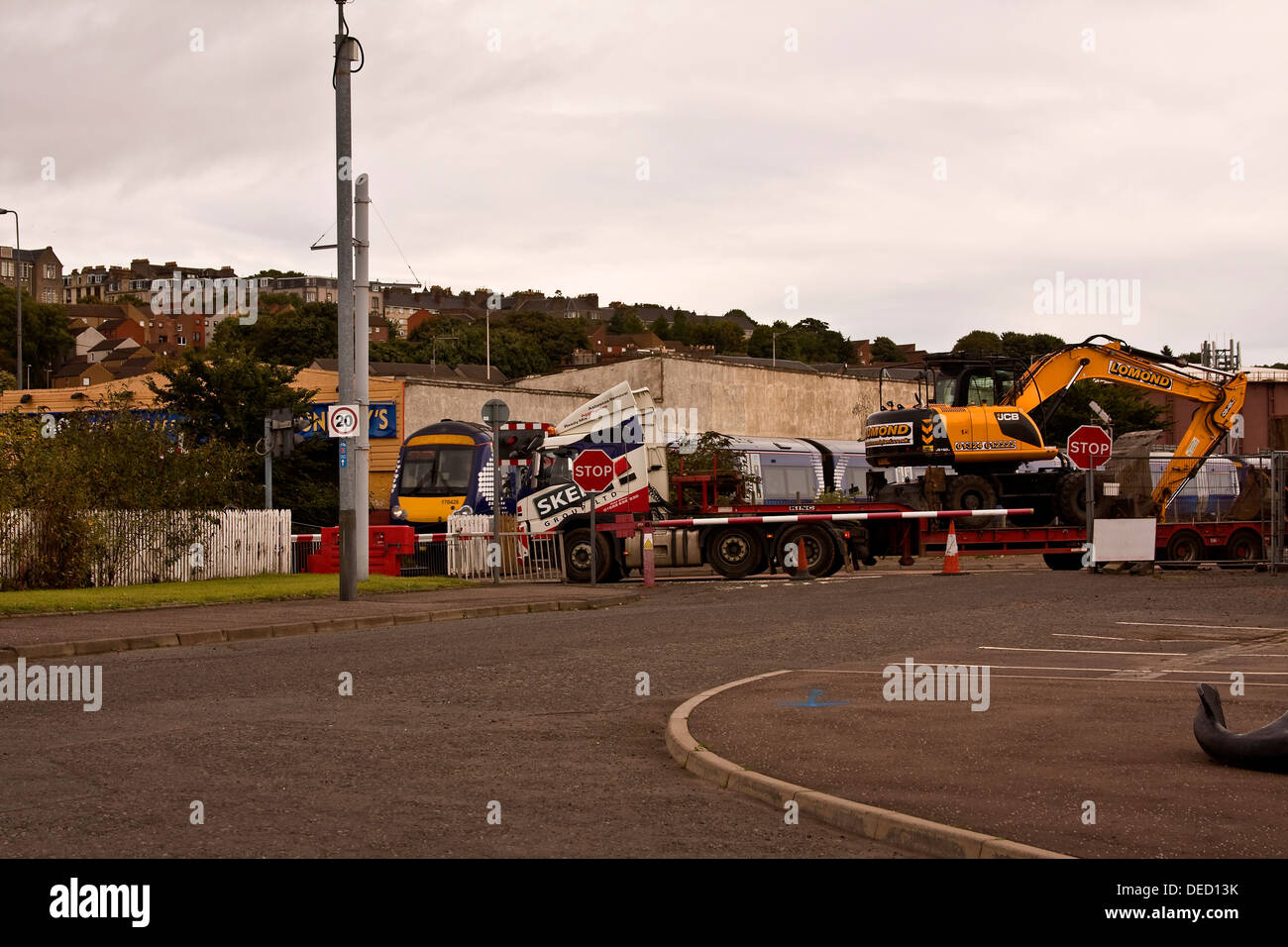 Transporter autocarro arrestato in corrispondenza del passaggio a livello lungo mentre un Scotrail approcci in treno la stazione ferroviaria di Dundee, Regno Unito Foto Stock