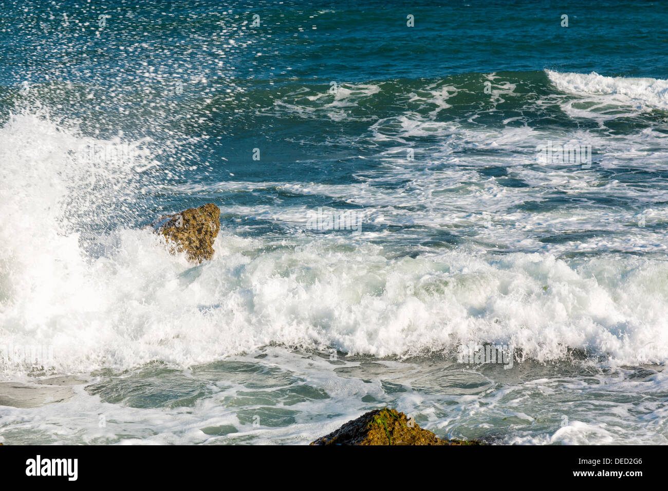 Mare, grande onda e schizzi su pietre in riva al mare Foto Stock