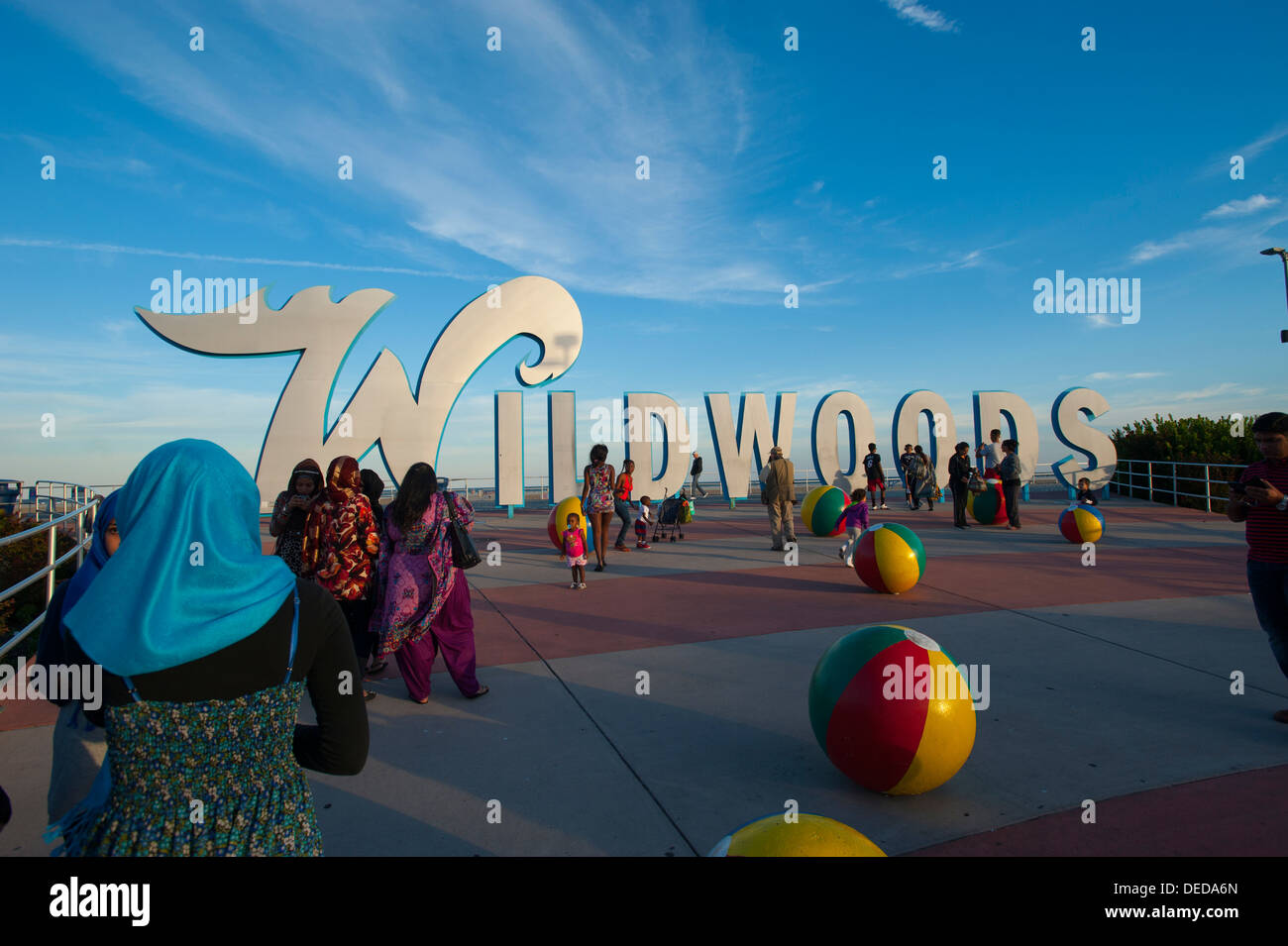 Stati Uniti d'America New Jersey NJ Wildwoods Boardwalk e firmare le persone raccolgono e giocare sulla spiaggia di metallo ballls artwork Foto Stock