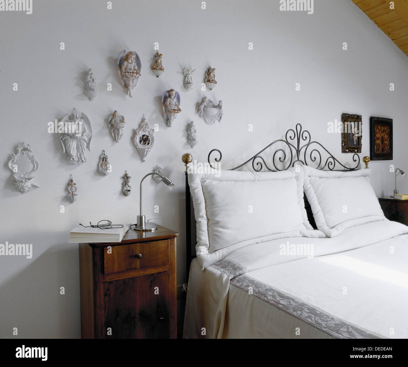 Il vecchio letto con una collezione di acquasantiere in soffitta Foto Stock
