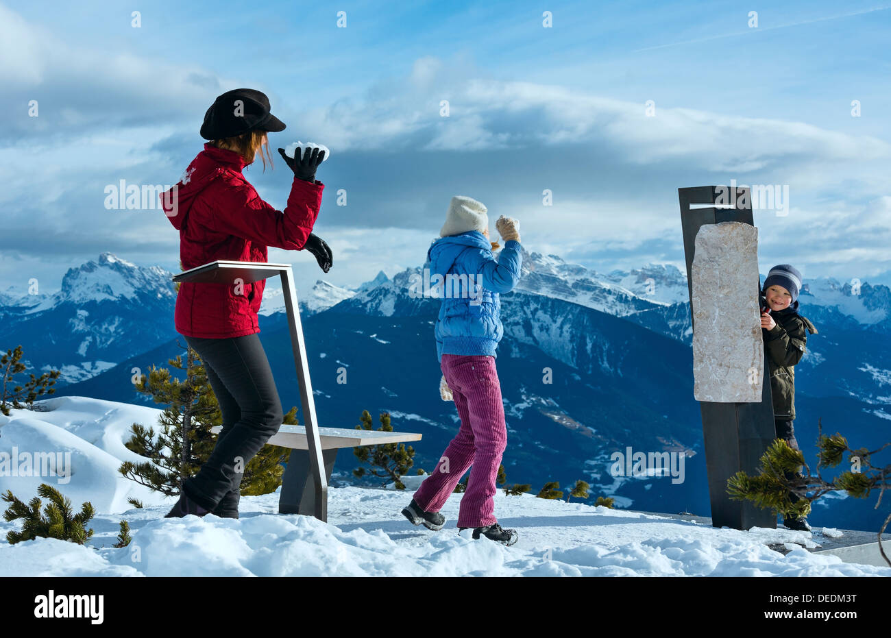 La famiglia (madre di due figli) gioca a snowballs sulla montagna invernale pendenza ( Corno del Renon, Italia) Foto Stock