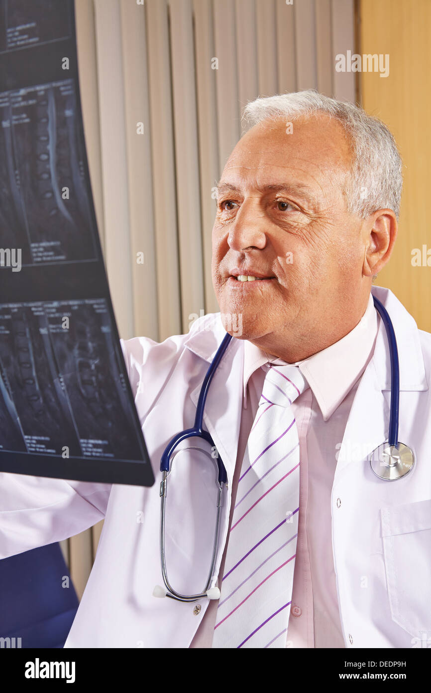 Medico con immagine a raggi x della colonna vertebrale umana nel suo ufficio Foto Stock