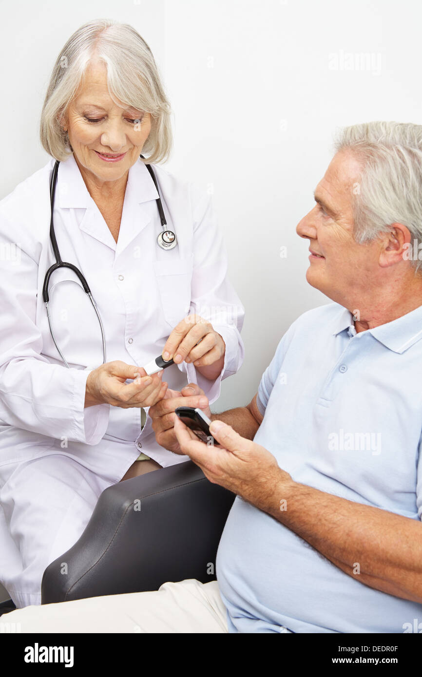 L'uomo anziano con diabete di ottenere i livelli di zucchero nel sangue la misura dal medico Foto Stock