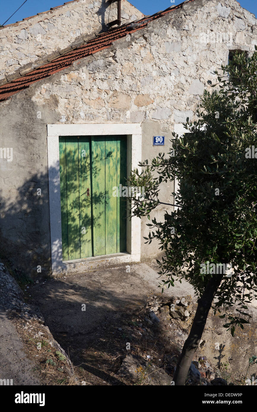 Tradizionale casa di pietra con la porta verde sull'isola di Mljet, Croazia Foto Stock