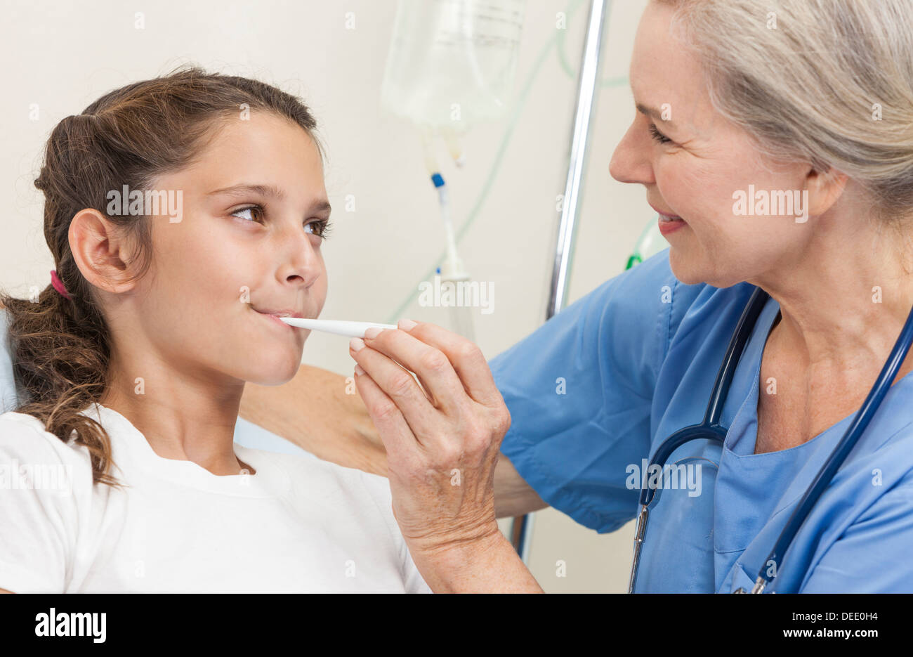 Il medico controlla la temperatura del neonato con un termometro. Un  infermiere in uniforme misura la febbre del bambino con un termometro Foto  stock - Alamy