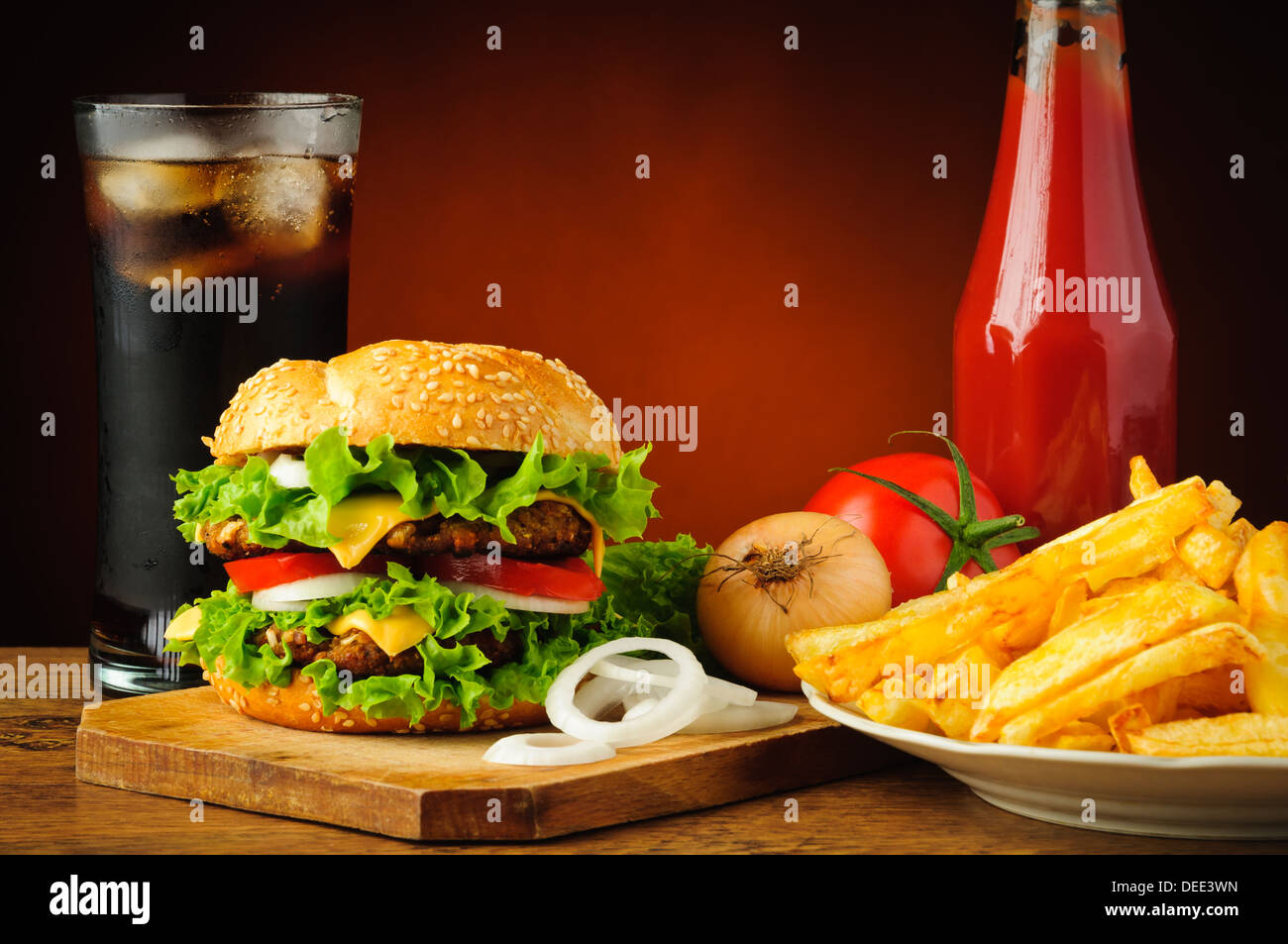 Il fast food menu con grande gustoso hamburger, verdure, patate fritte, ketchup e bevanda di cola Foto Stock
