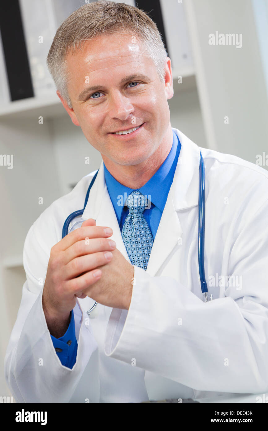 Sorridenti maschio medico nel suo ufficio dell'ospedale Foto Stock