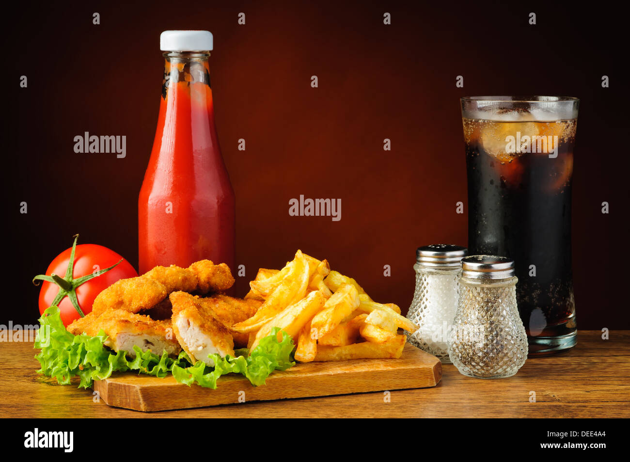 Ancora vita con fast food menu, pepite di pollo e patatine fritte, cola e tomato ketchup Foto Stock