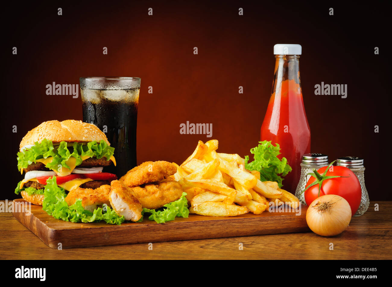 Il fast food menu con hamburger o cheeseburger, tradizionale patatine fritte, pepite di pollo, cola e tomato ketchup Foto Stock