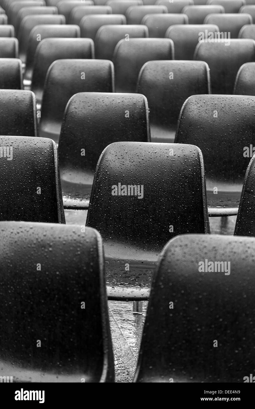 Sedie di plastica sotto la pioggia Foto Stock