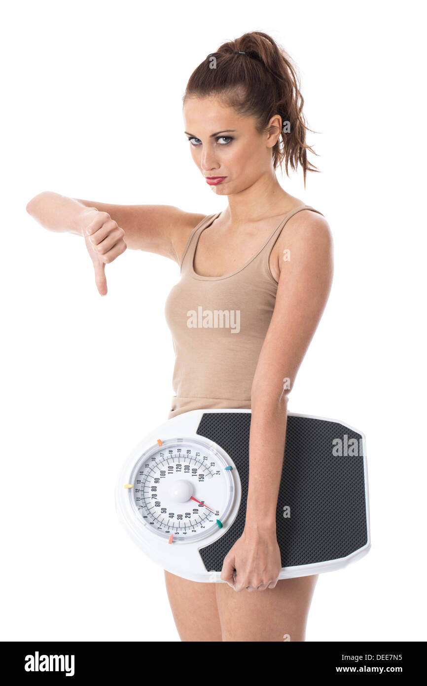 Positivo fiducioso giovane donna, controllare il suo peso sulla bilancia da bagno, giubbotto da indossare top, isolata contro uno sfondo bianco Foto Stock