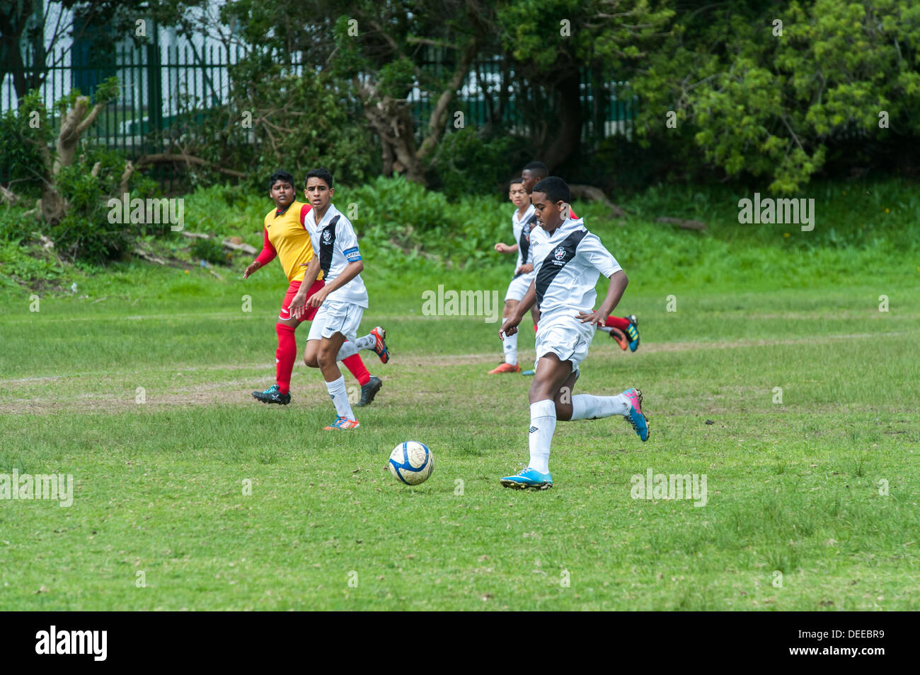 Junior i giocatori di calcio in esecuzione con la palla, Cape Town, Sud Africa Foto Stock