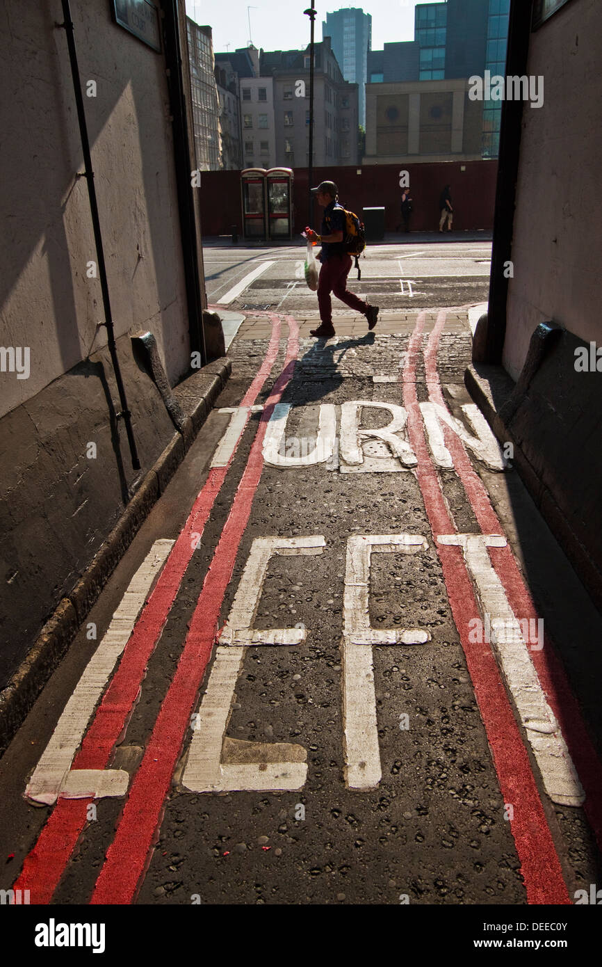 Girare a sinistra oltre il doppio di linee rosse della segnaletica stradale nella città di Londra Foto Stock
