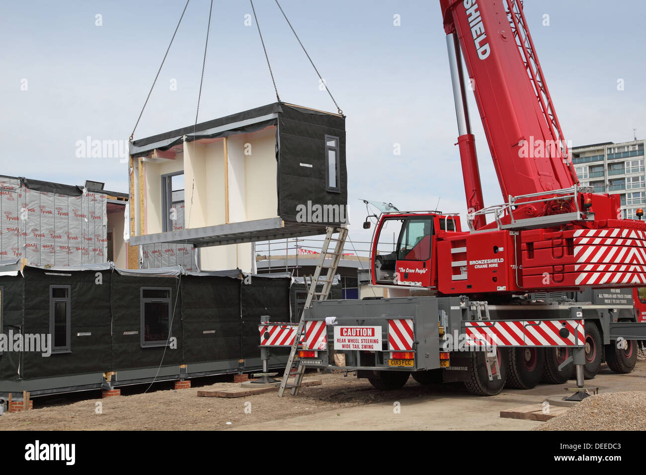 Una gru solleva una sezione modulare di un nuovo edificio scolastico in sede nel sud di Londra, Regno Unito Foto Stock