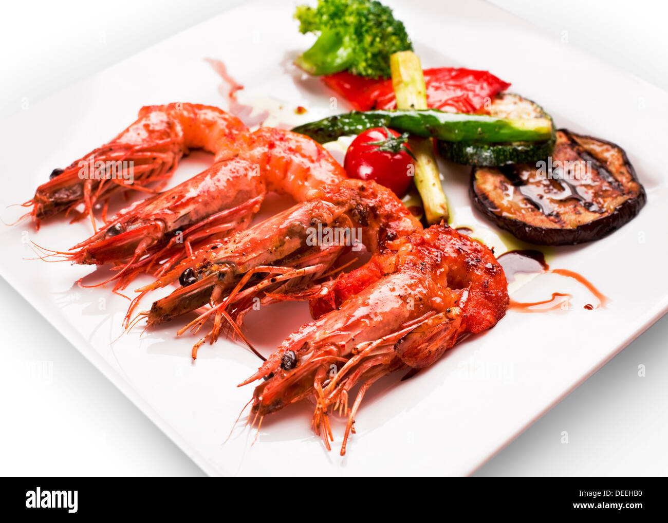 I gamberi alla griglia e verdura su una piastra bianca. Foto Stock