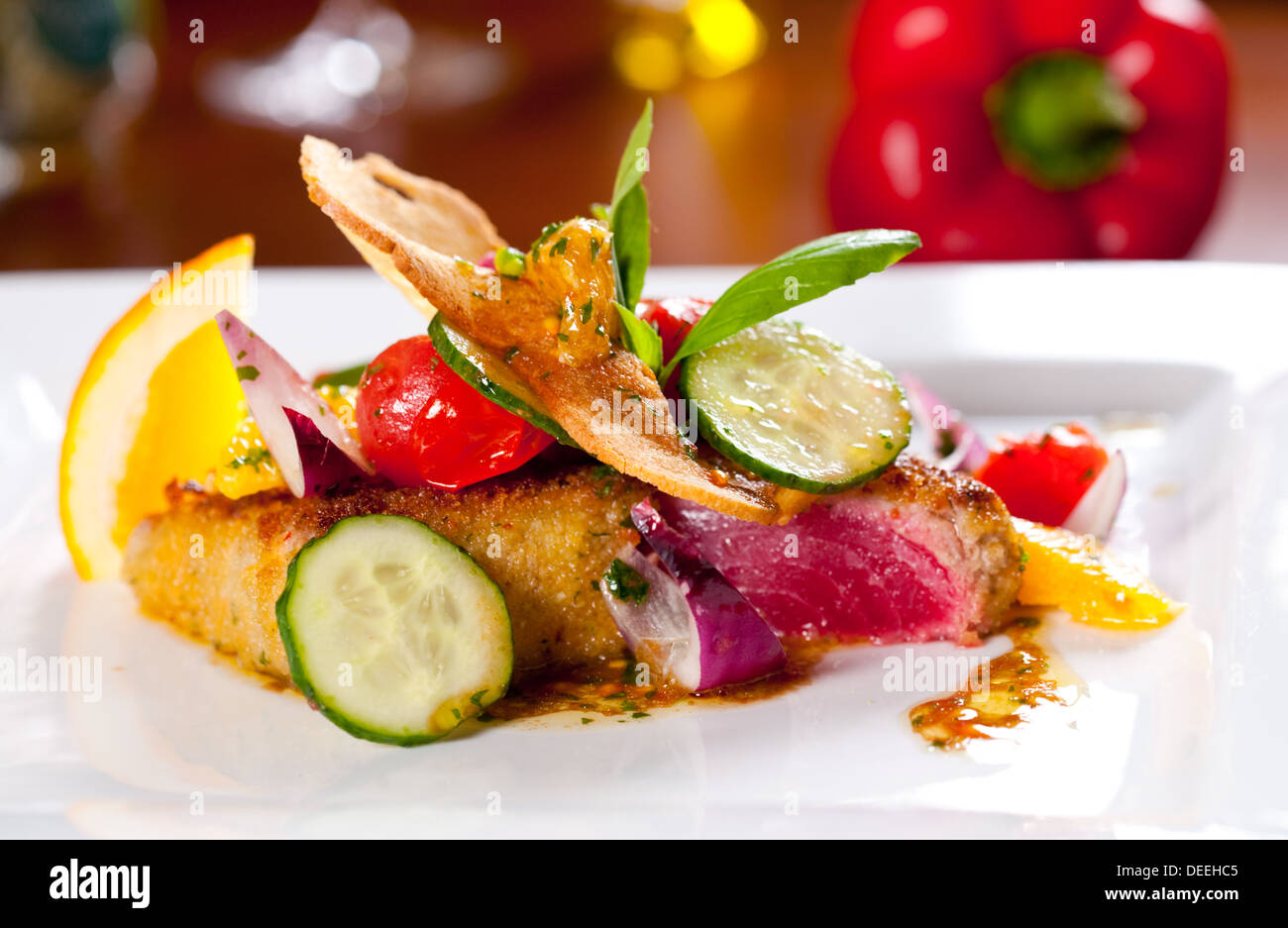 Pasto leggero dal tonno alla griglia su una piastra bianca con paprika sullo sfondo. Foto Stock