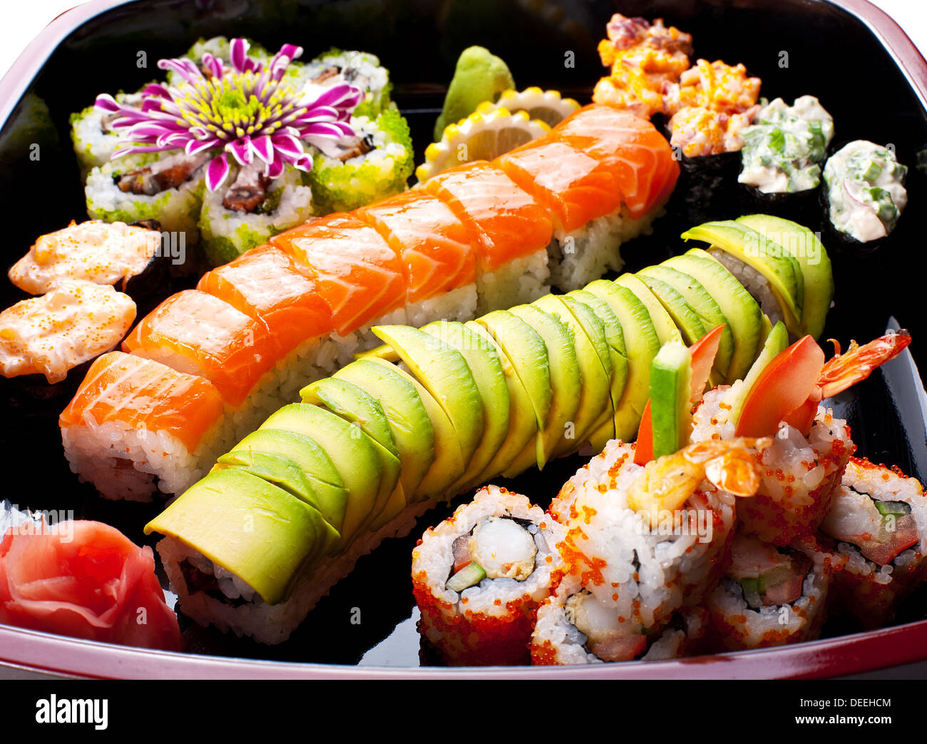 Diversi rotoli di sushi su una piastra nera. Foto Stock