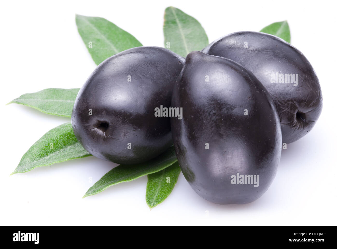 Tre grandi maturi olive nere con foglie isolate su un bianco. Foto Stock