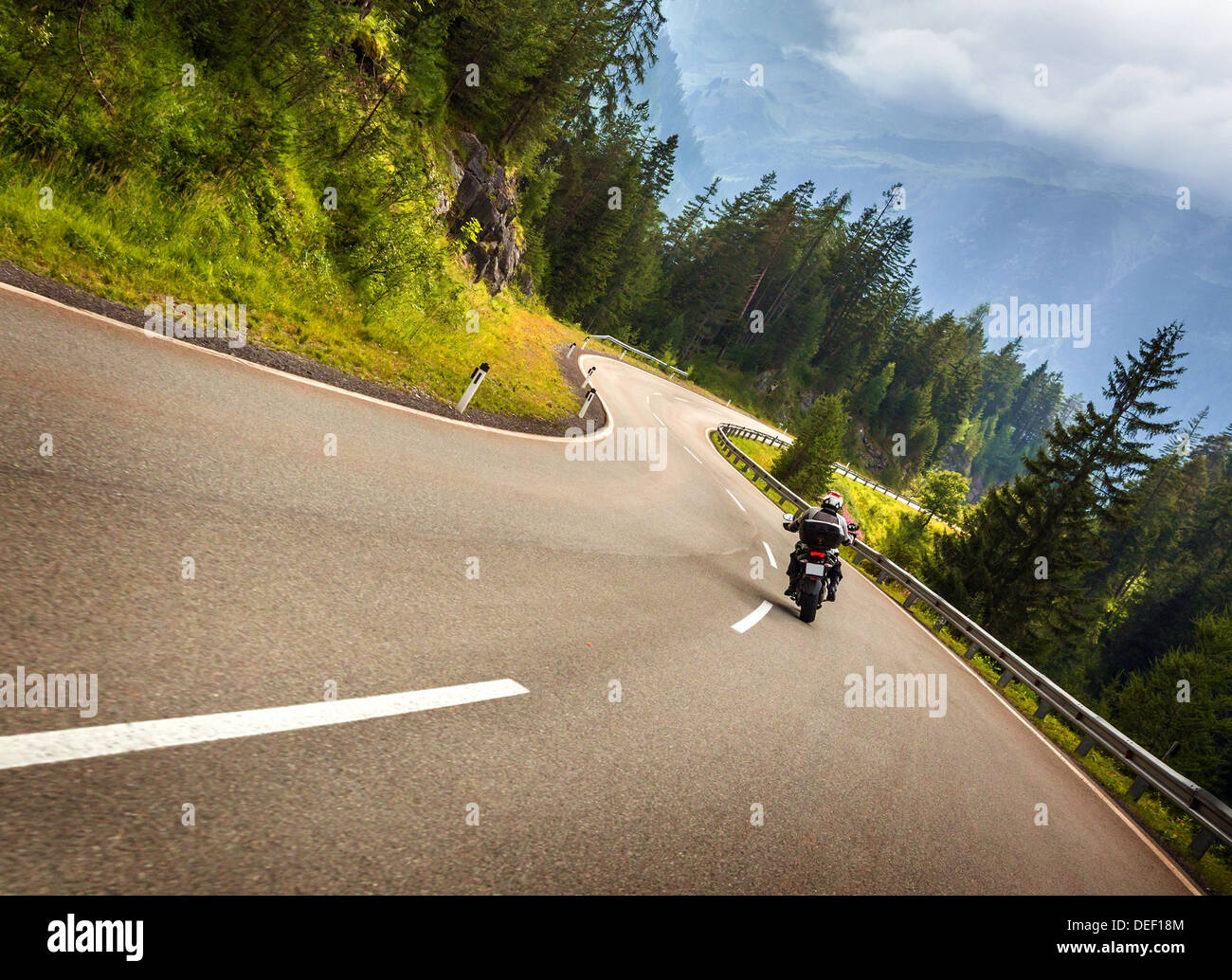 Biker in montagne austriache equitazione sulla strada curva, Alpi, l'Europa, la velocità e il concetto di libertà, trasporto di lusso, active travel Foto Stock