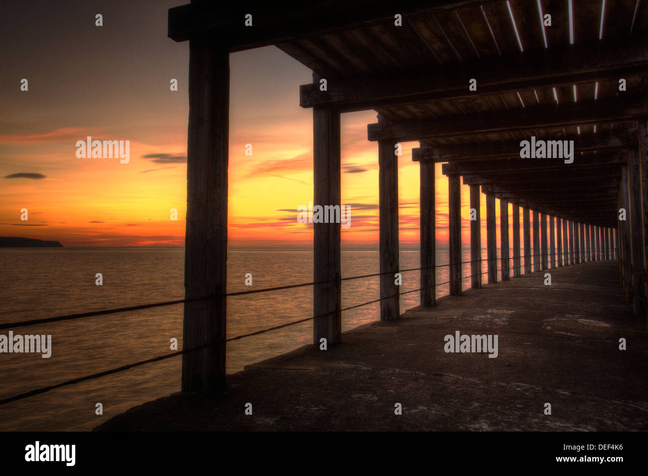 Al di sotto di Whitby Molo Ovest, North Yorkshire, tramonto Foto Stock