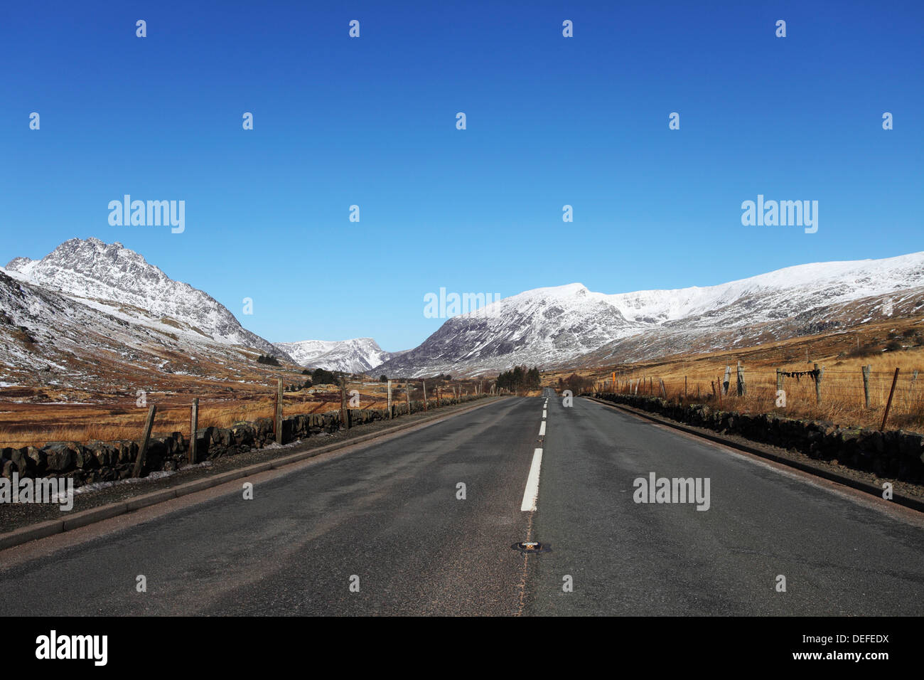 L'A5 strada scorre attraverso il passato montagne innevate nel Parco Nazionale di Snowdonia, Wales, Regno Unito, Europa Foto Stock