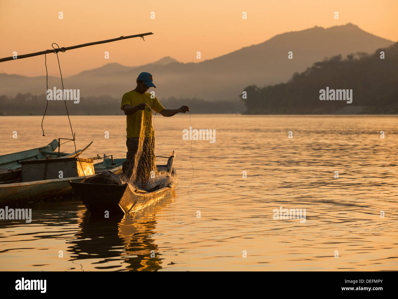 L'uomo la bobinatura in rete da pesca sul fiume Mekong, Luang Prabang, Laos, Indocina, Asia sud-orientale, Asia Foto Stock