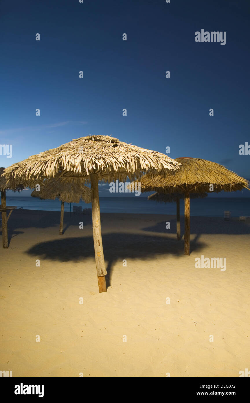 Una vista serale di una spiaggia e fornitori di ombra a Varadero, Cuba. Foto Stock