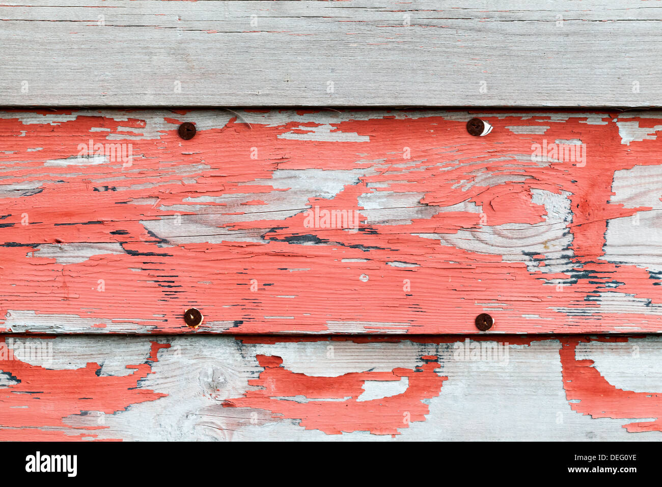 Vecchia pubblicità obsoleti pareti in legno con vernice rossa e puntine arrugginite Foto Stock