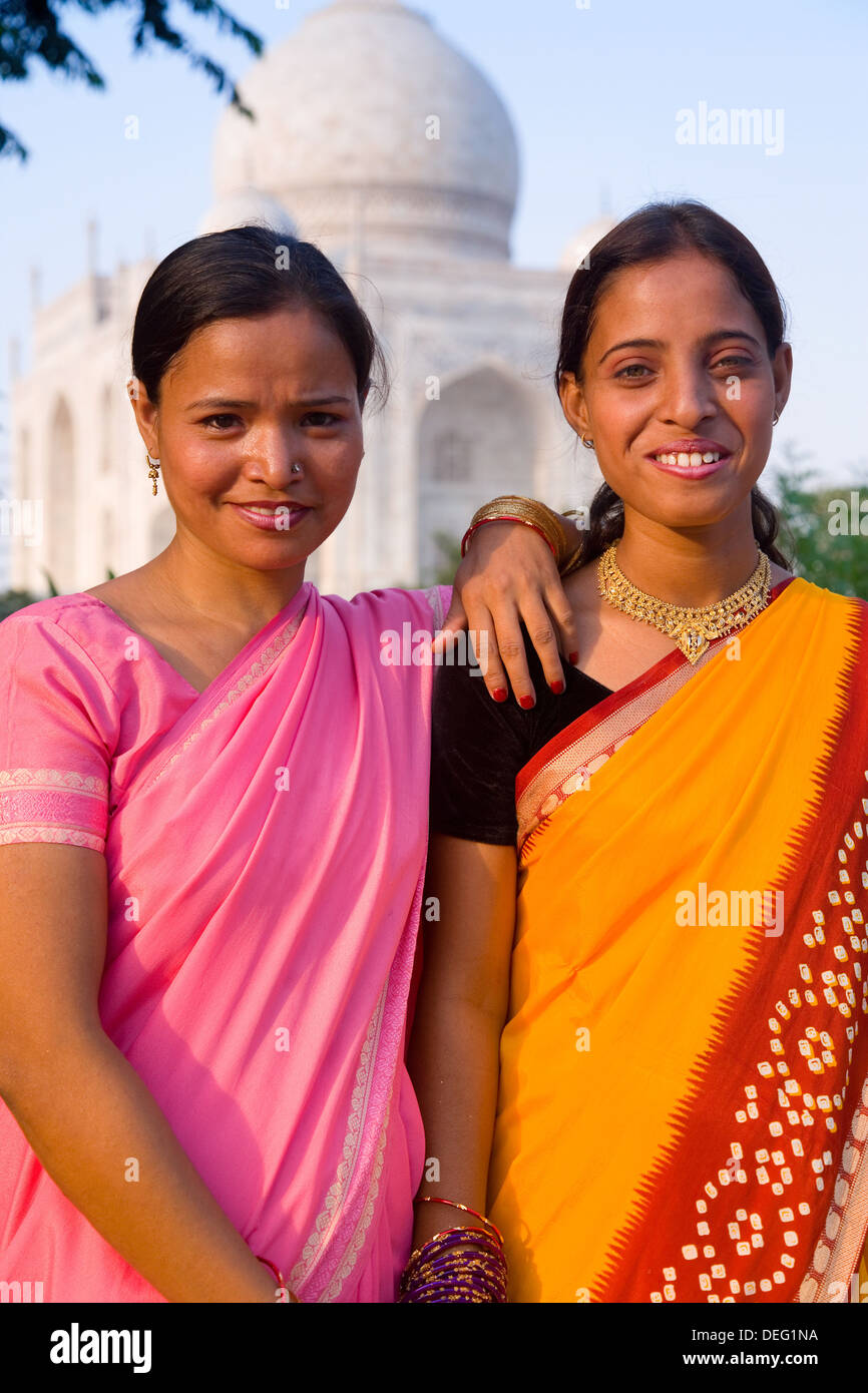 Due donne pongono di fronte al Taj Mahal, Sito Patrimonio Mondiale dell'UNESCO, Agra, Uttar Pradesh, India, Asia Foto Stock