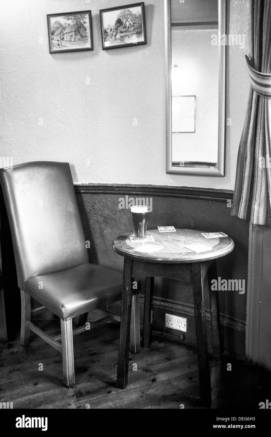 Una pinta di birra in una tavola in un pub Inglese. Foto Stock