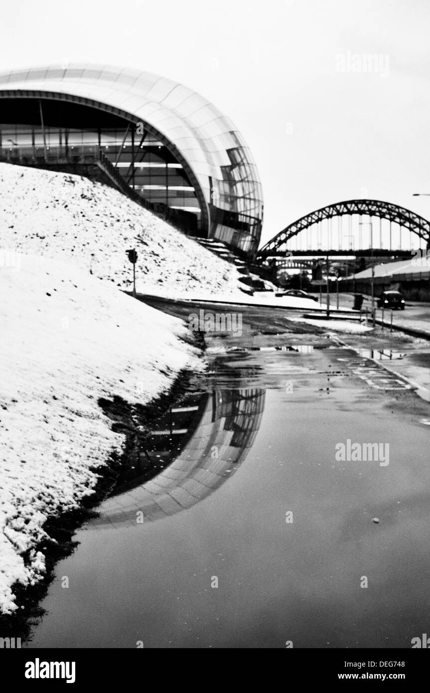 Una scena invernale che mostra il centro di Sage Gateshead con il Tyne Bridge in background. Foto Stock