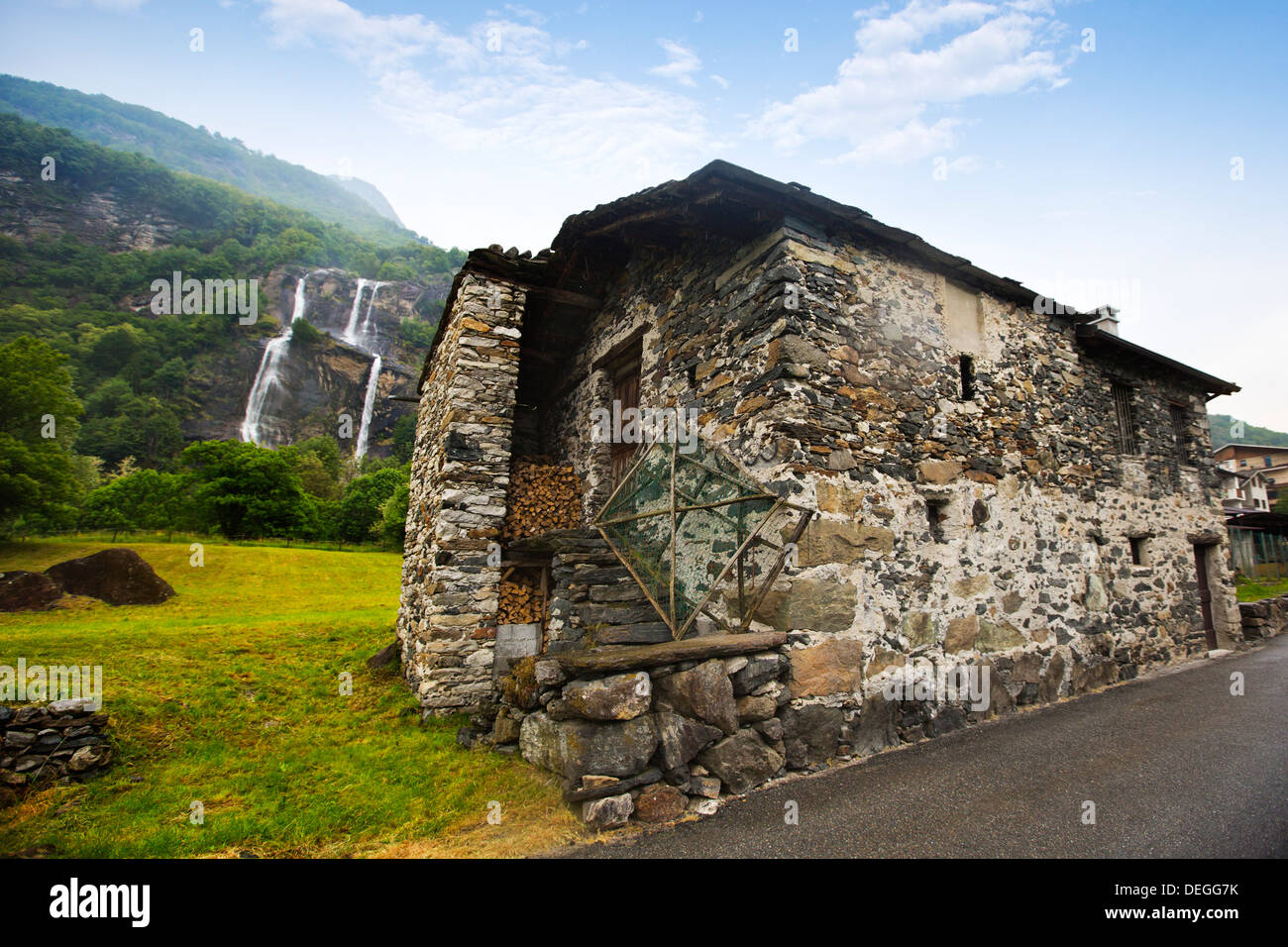 Casa abbandonata in un villaggio con cascata in background, Como, Lombardia, Italia Foto Stock