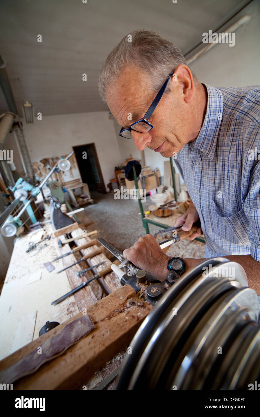 Artigiano lavorare il legno sul tornio dentro il suo laboratorio Foto Stock