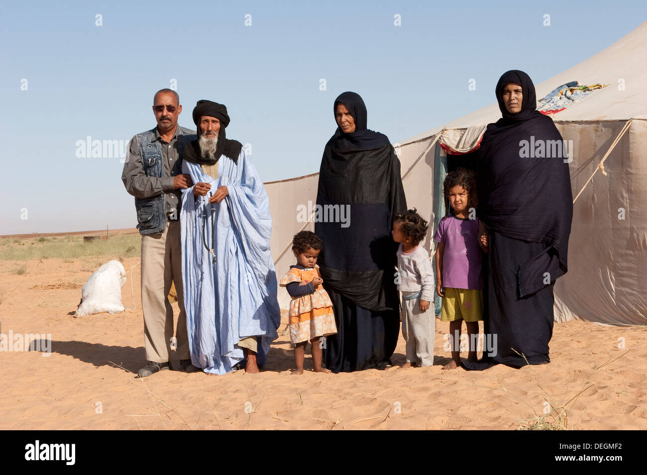 Islamico famiglia nomade al di fuori della propria tenda con zona community liaison officer, NW deserto del Sahara, Mauritania, Africa occidentale Foto Stock