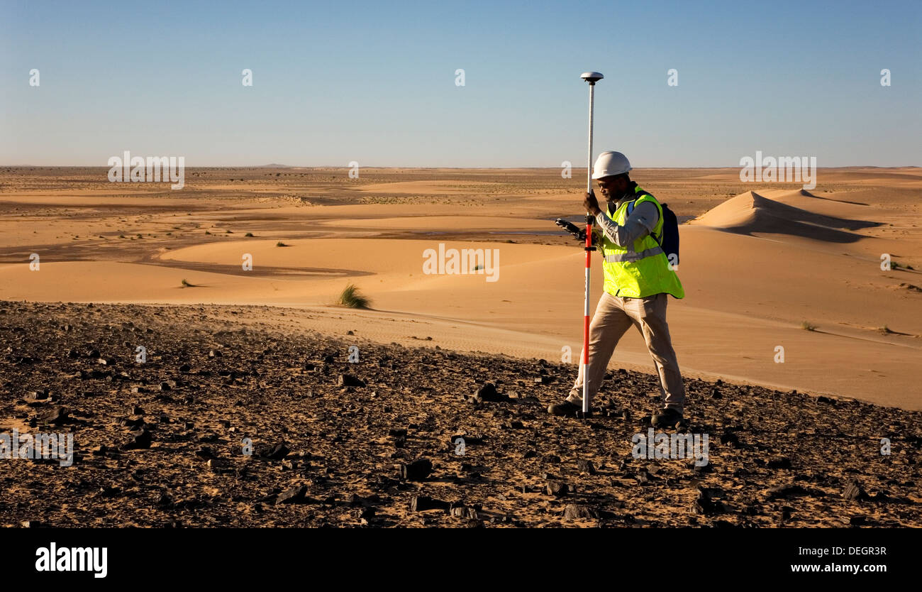 Geometra geologico utilizzando il GPS differenziale di attrezzatura per un digital terrain sondaggio nelle dune del deserto del Sahara, Mauritania Foto Stock