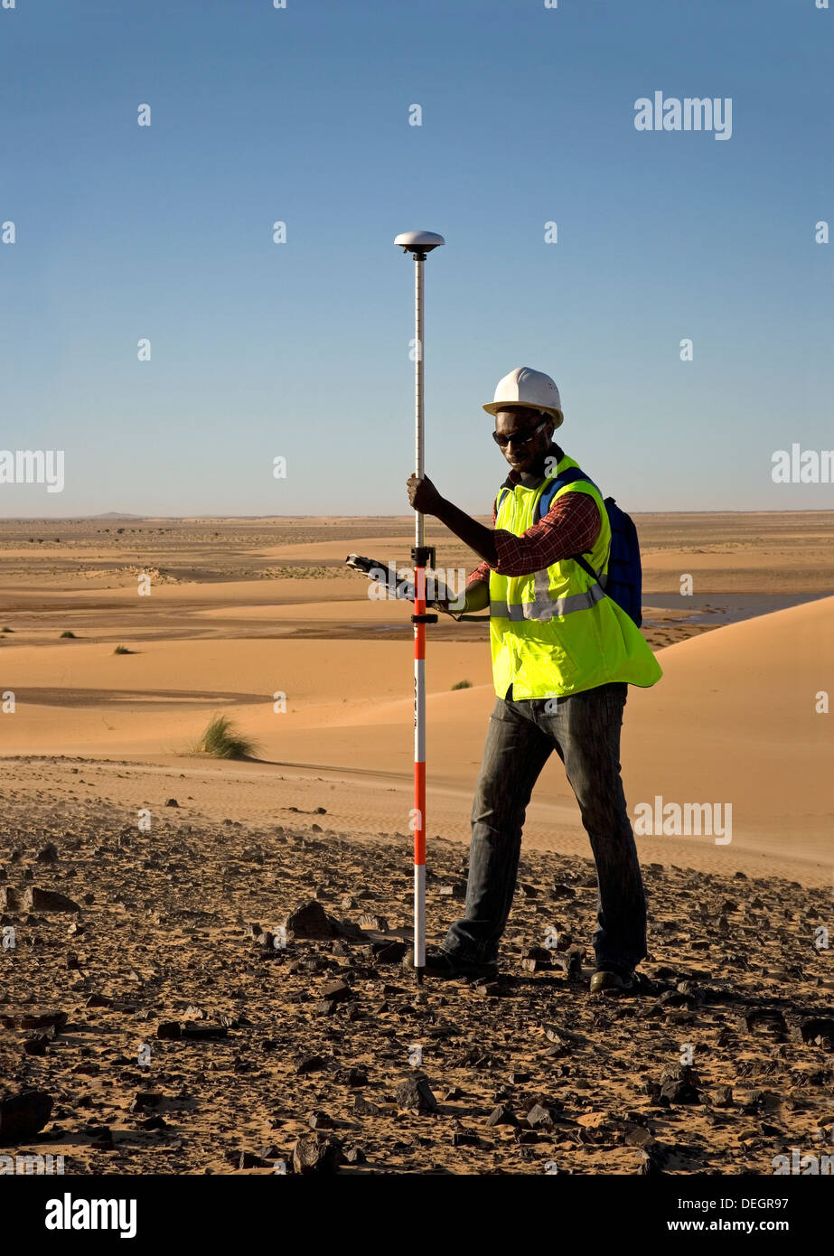 Geometra geologico utilizzando il GPS differenziale di attrezzatura per un digital terrain sondaggio nelle dune del deserto del Sahara, Mauritania Foto Stock