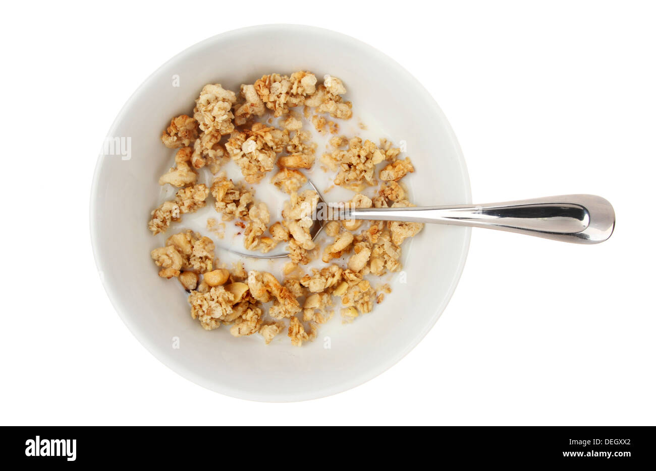 Ciotola del cluster del dado a base di cereali con latte e un cucchiaio isolata contro bianco Foto Stock