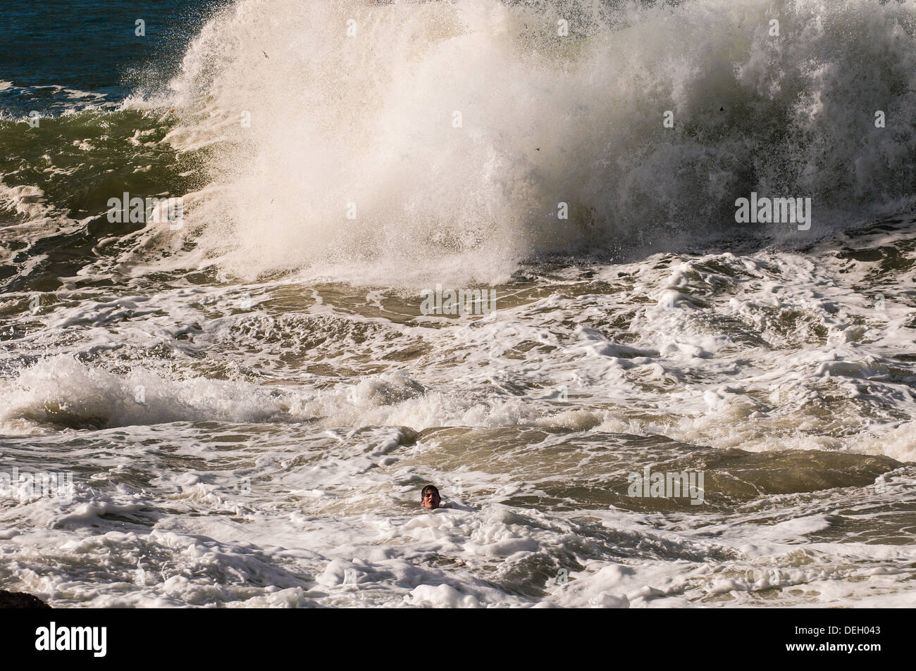 Ragazzo adolescente in difficoltà in big surf a Snapper Rocks, Gold Coast, Queensland, Australia Foto Stock