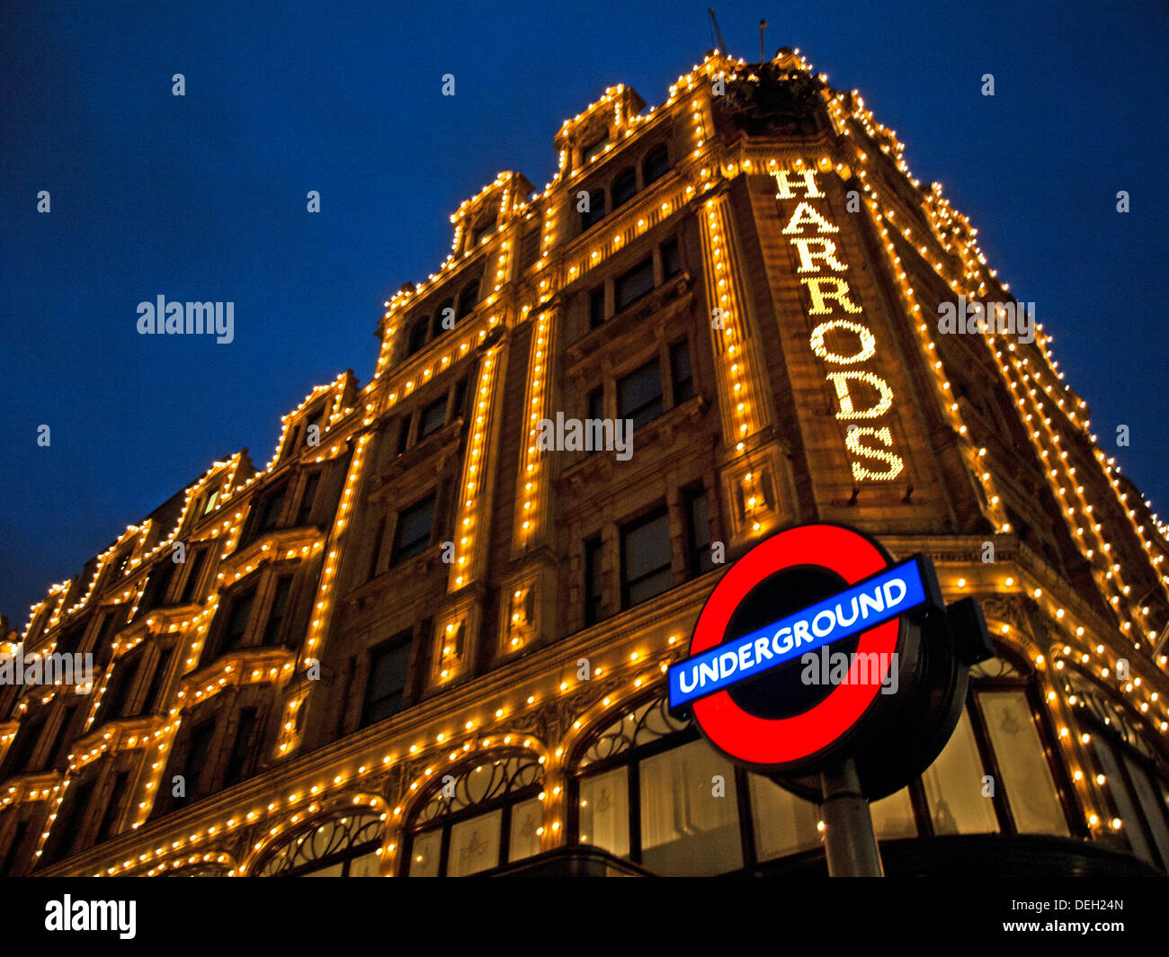 I grandi magazzini Harrods di notte mostra London Underground segno, Knightsbridge, Royal Borough di Kensington e Chelsea Foto Stock