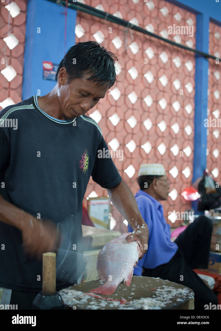 Ridimensionamento in scala di pesce fresco nel mercato, Labuan, Malaysia Foto Stock