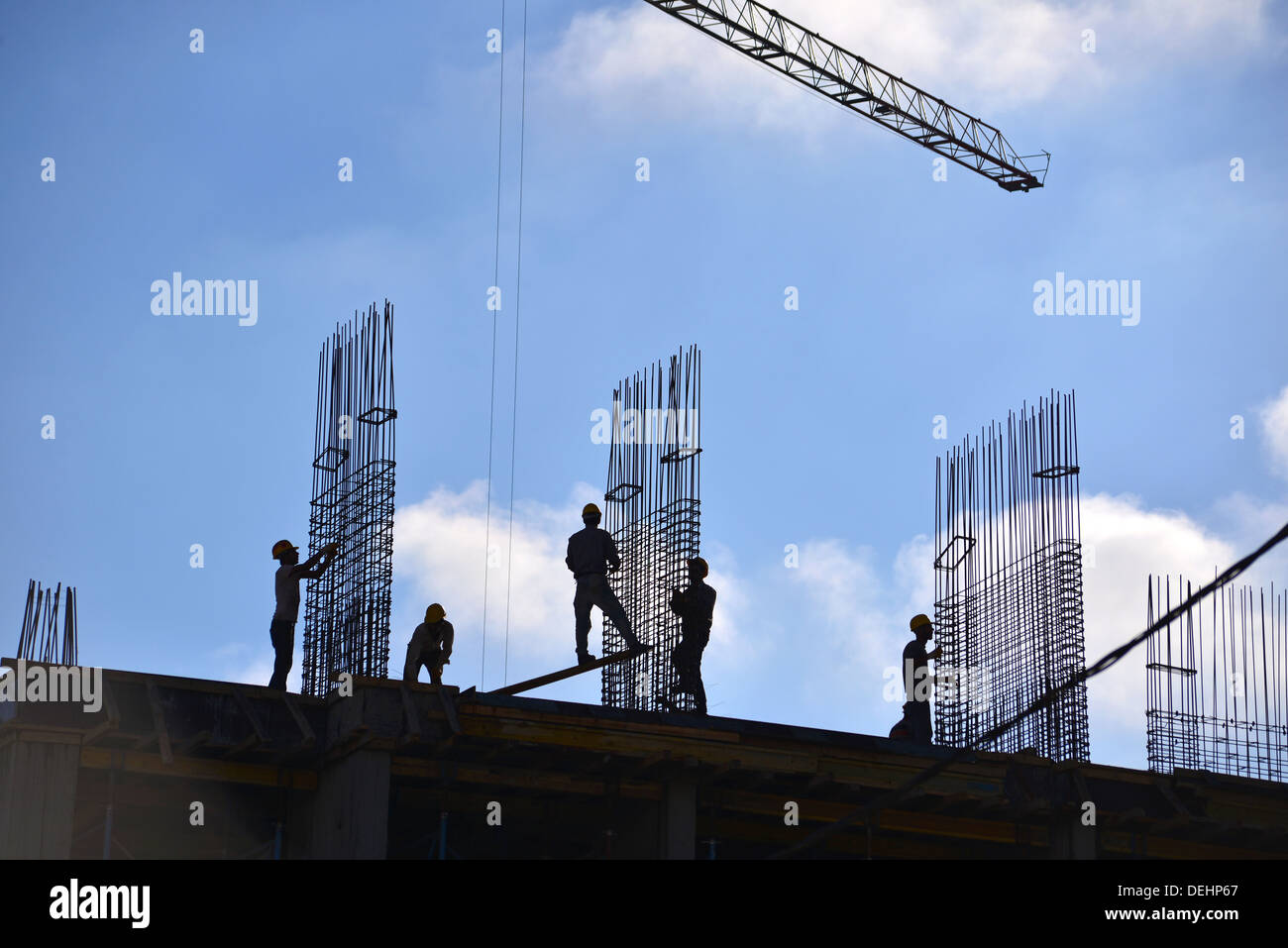 Silhouette di persone che lavorano e costruzione edilizia Foto Stock