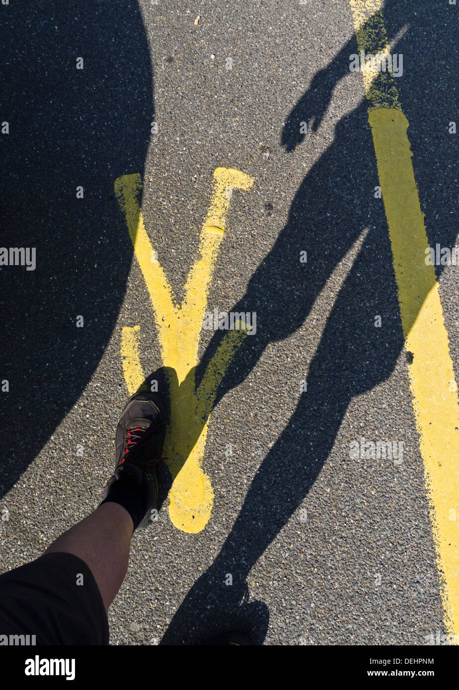 Ombra di un uomo che cammina in una zona pedonale. Foto Stock