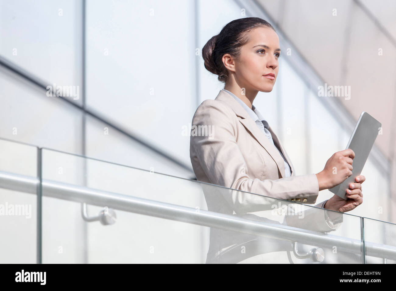 Bella giovane imprenditrice azienda digitale compressa ringhiera di office Foto Stock