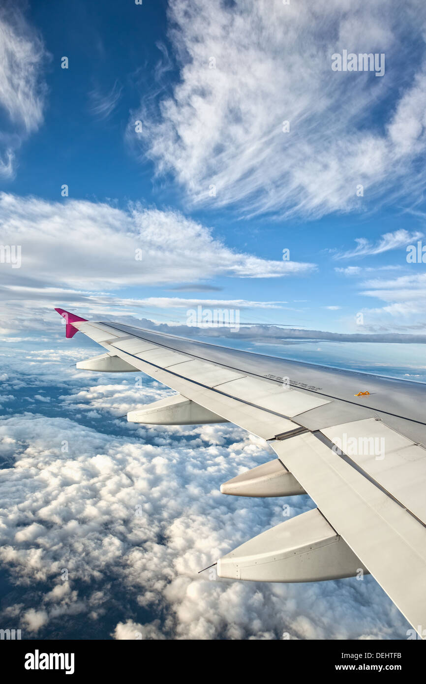 Ala di aeroplano contro il cielo blu e nuvole Foto Stock