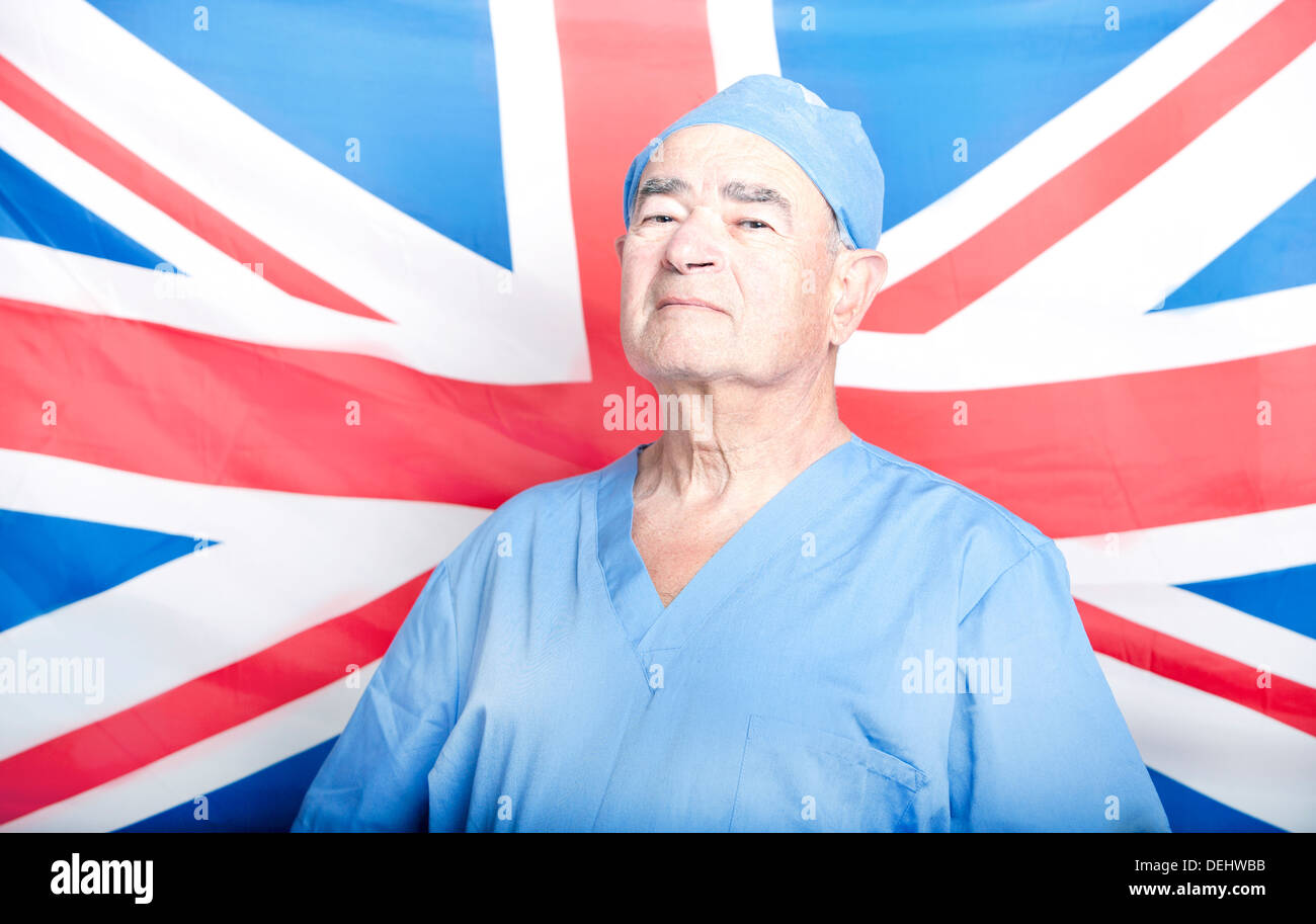 Ritratto di un adulto Senior chirurgo davanti una bandiera britannica Foto Stock