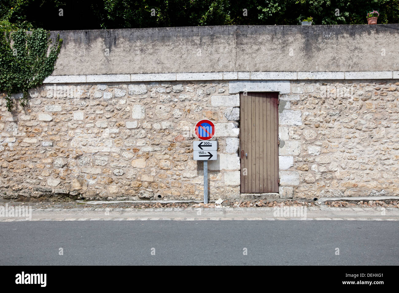 Nessun segno di parcheggio contro il muro di pietra Foto Stock
